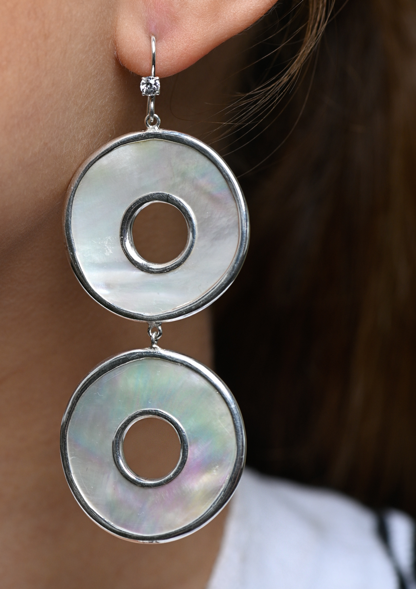 Mother of pearl discs set 950 sterling silver, with a diamond-cut Ceylonese white sapphire on the S hook.